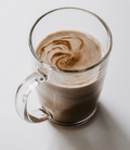 Hot chocolate mocha made with espresso and steamed milk in a clear glass mug