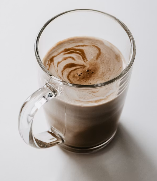 Hot chocolate mocha made with espresso and steamed milk in a clear glass mug