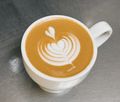 Flat white with silky microfoam and latte art in a white ceramic cup